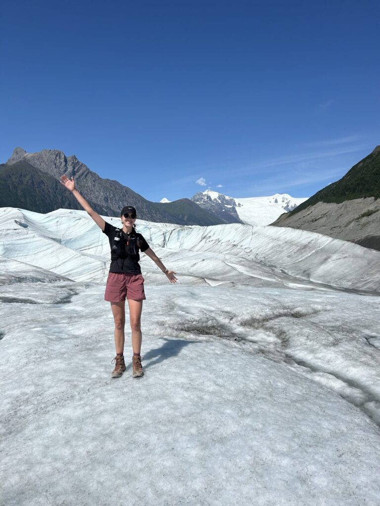 Image showing a hiker on an Alaskan Glacier with clear blue skies and ridgelines in the bachground
